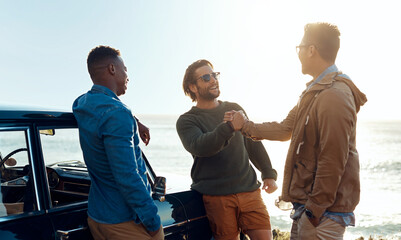 Obraz premium Friends, handshake and road trip with men on coast together for bonding, hangout or social gathering. Greeting, reunion and travel with happy people shaking hands at seaside for holiday or vacation