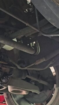 Auto repair process under a car with a focus on mechanical work