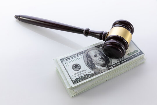 Judge gavel on stack of US dollar bills representing legal costs and financial judgment