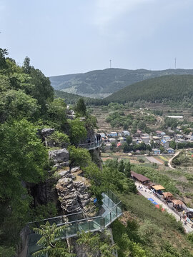 Mountain glass skywalk above rural valley and forested hills