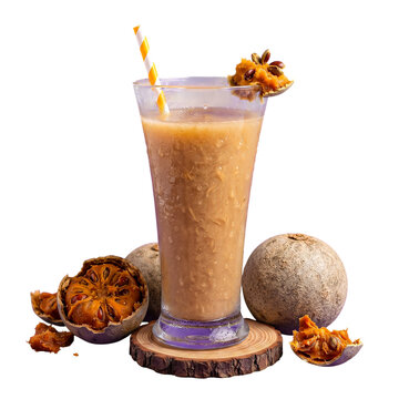 A refreshing glass of wood apple juice served with fresh whole and broken wood apple fruits isolated on black