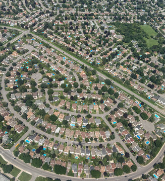 An aerial view of a sprawling suburban neighborhood in summer