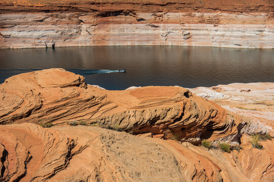 A speed boat cruises on a scenic Lake Powell