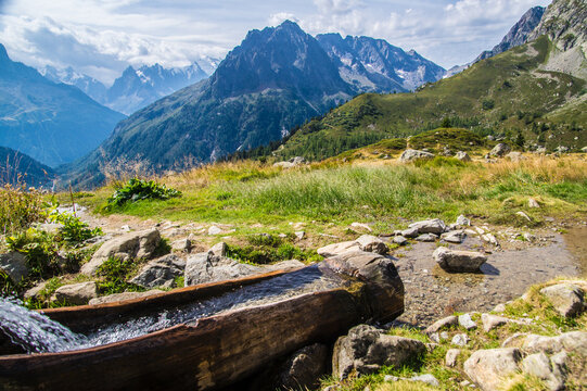 Mountain landscape with fresh water trough in Alps