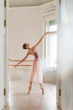 Elegant ballerina posing gracefully in a sunlit dance studio