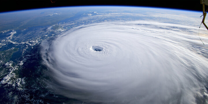 A powerful hurricane seen from space, with its eye clearly visible and swirling clouds stretching across the ocean. This image captures the immense force and scale of nature's weather phenomena