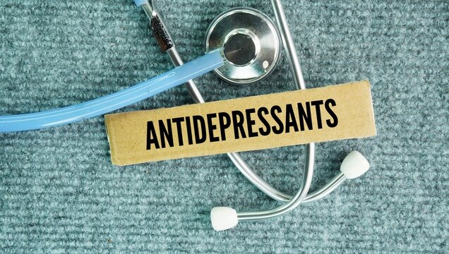 Stethoscope and paper box with the words Antidepressants are prescription medications used to relieve symptoms of depression, anxiety disorders, and other chronic conditions