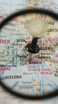 Magnifying glass highlights Monaco on printed map