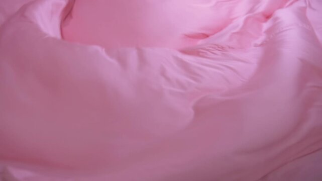 A pink sheet of fabric with a wave pattern