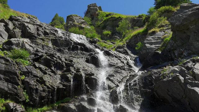 Waterfall descending across a rugged rock face near the Transfagarasan in the Romanian Carpathians