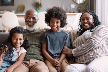 Obraz premium Grandparents, happy children and portrait in home with love, care and bonding on weekend together. Siblings, grandmother and grandfather on sofa with support, smile and relax with African family