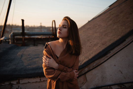 Young woman basking in the warm glow of an autumn sunset on a rooftop