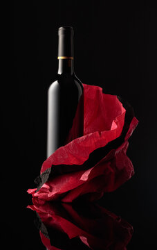Bottle of red wine on a crumpled paper.