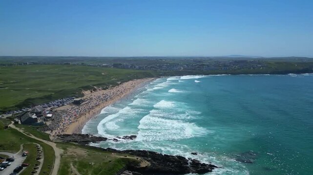 Newquay, North Cornwall, England: DRONE VIEWS: A low angle of surfers in the sea waiting for incoming waves off Fistral Beach. Fistral bay is a venue for major international surfing competitions.