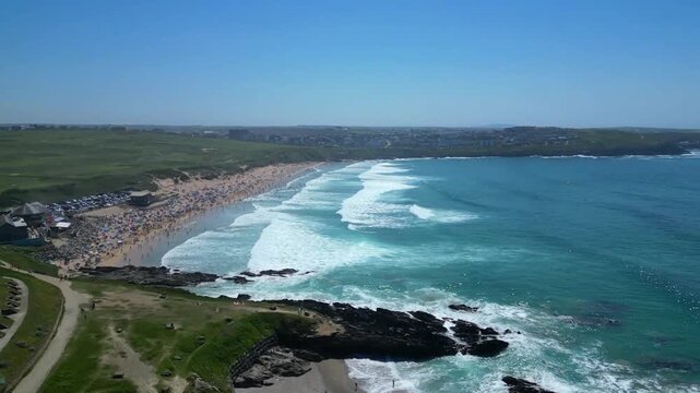 Newquay, North Cornwall, England: DRONE VIEWS: A low angle of surfers in the sea waiting for incoming waves off Fistral Beach. Fistral bay is a venue for major international surfing competitions.