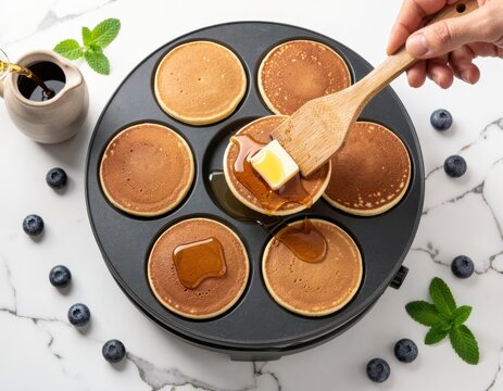 Fresh mini pancakes being prepared in a special pan