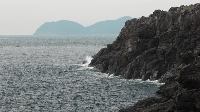 4K cinematic slow motion of rugged rocky cliffs and a calm sea along the Japanese coastline
