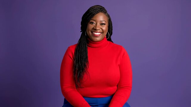 A smiling woman wearing a red sweater against a purple background