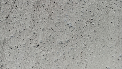 Fototapeta premium Close Up Grey Dirt Road Surface with Fine Dust and Pebbles Texture Background