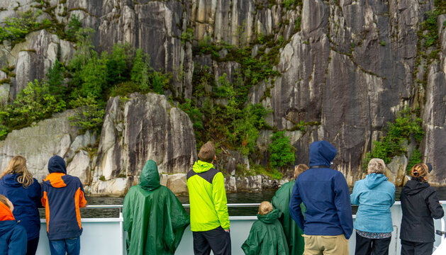 Tourists watching Preikestolen cliff and Lysefjord landscape from boat tour