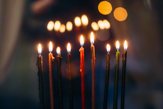 Hanukkah candles illuminating dark background with bokeh lights