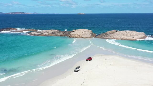 Aerial view of off road vehicles driving along pristine white sandy beach at Lucky Bay in Cape Le Grand National Park Australia.