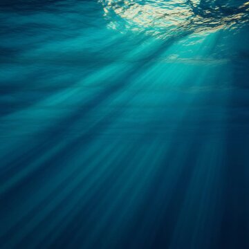 Sunlight rays streaming through the deep blue ocean water surface.