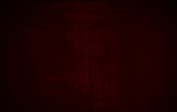 Painted dark red concrete wall with lighter marks as a result of graffiti removal. Grungy high resolution full frame background. Front view, copy space.