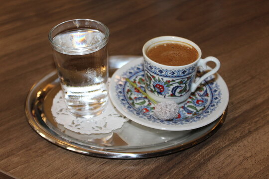Turkish espresso in a small cup with a glass of water.
