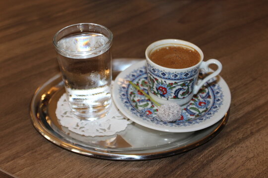 Turkish espresso in a small cup with a glass of water.