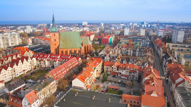 Drone shot of Kołobrzeg at sunrise in March, highlighting the stunning Basilica of the Assumption in the heart of the city.