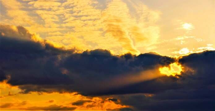 Sunset sky with dramatic clouds with rays of light shines bright, heavenly scene, clouds and light background