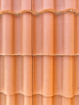 Flat background pattern of classic orange clay interlocking roof tiles
