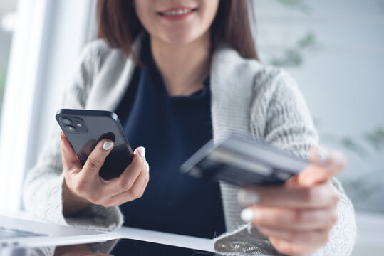 Young asian woman using smartphone and credit card for mobile banking, digital payment via mobile app, financial technology, e-commerce concept