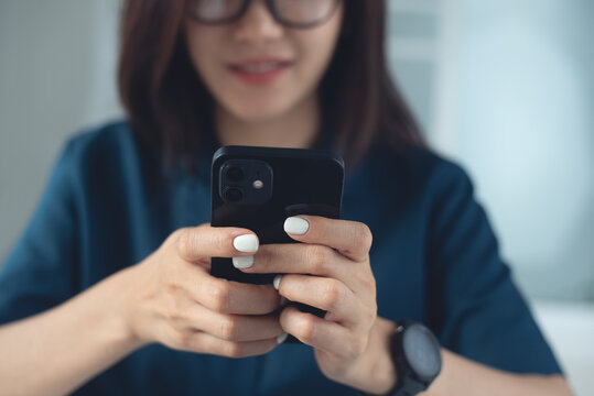 Young asian woman smiling during using smartphone for social network at home, modern people lifestyle, digital communication concept