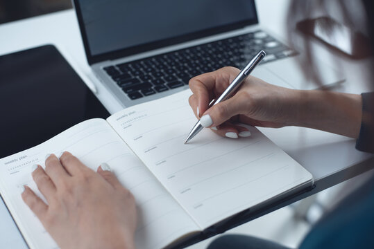 Event planner timetable agenda plan on schedule event. Business woman checking weekly planner, taking note on calendar notebook on office desk. business project planning