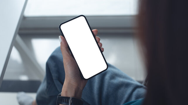 Mockup, woman using mobile phone with white empty screen with office background, template for mobile app design and online marketing