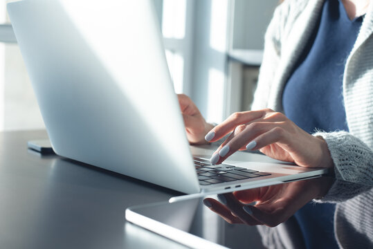 Closeup, business woman typing on laptop at office with digital tablet on desk. surfing the internet, digital work concept