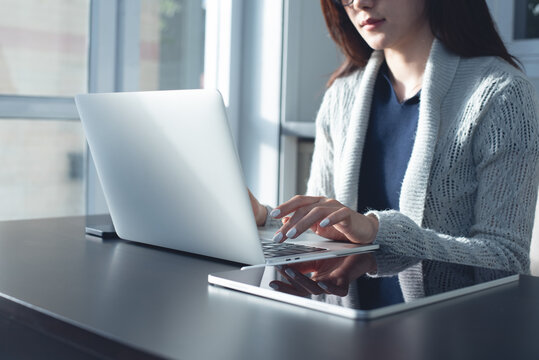 Asian business woman working on laptop at office with digital tablet on table. surfing the internet, searching the information