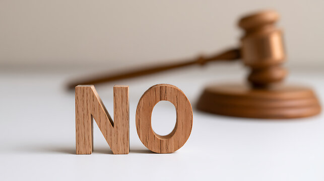 Wooden letters spelling the word no placed in front of a judge gavel on a white background representing legal denial and court verdict