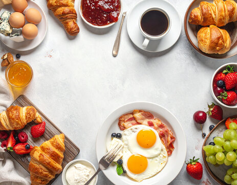 Delicious breakfast table with eggs croissant and coffee
