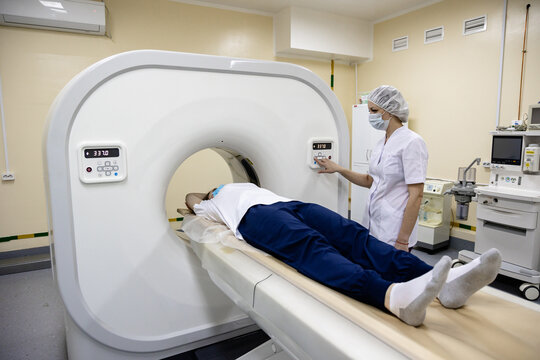 Radiology Technician Performing CT Scan on Adult Patient