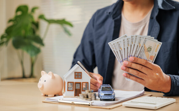 A man with cash, house, and car models symbolizes saving and managing finances. Includes loan strategies, tax benefits, and property investments