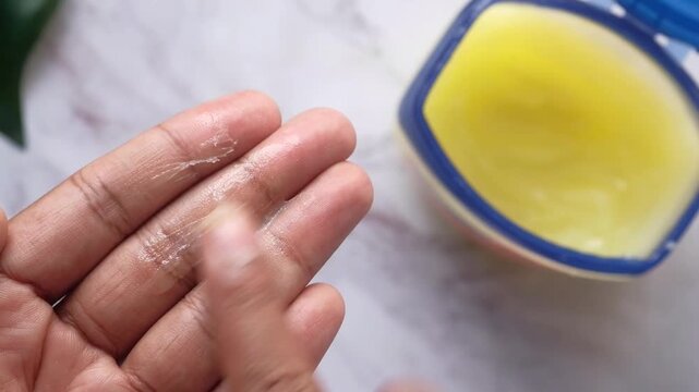 Close up of hands applying petroleum jelly for skin hydration motion footage