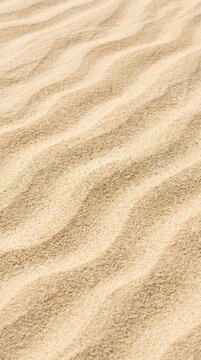 Golden beach sand texture with natural wind ripples forming a soft wavy pattern