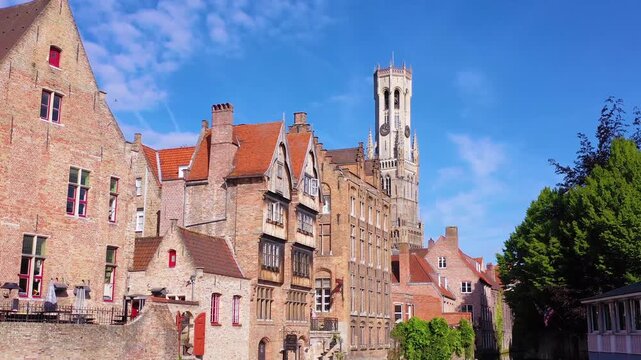 Beautiful medieval brick buildings along a peaceful canal in historic center of Bruges during sunny spring day.