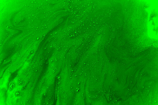 Abstract neon green liquid surface with bubbles and swirling foam, resembling toxic slime, chemical waste or radioactive contamination.
