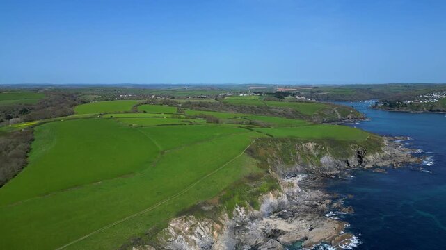River Fowey, Cornwall, England: DRONE VIEWS: The drone flies over the South West Coast Path showing the River Fowey estuary; to the right of picture is the riverside village of Polruan.
