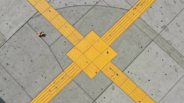 Aerial angle of yellow tactile ground indicators for visually impaired on pavement