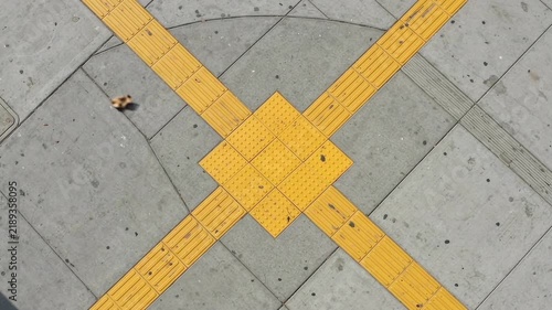 Aerial angle of yellow tactile ground indicators for visually impaired on pavement